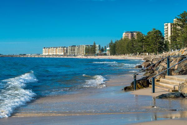 Glenelg beach coastline in Adelaide South Australia with trees and building in the background